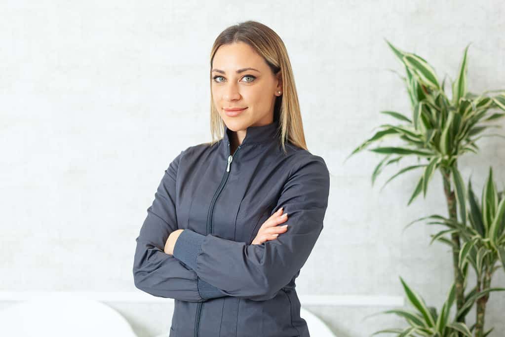 Portrait of a beautiful smiling woman with blond hair and green eyes.