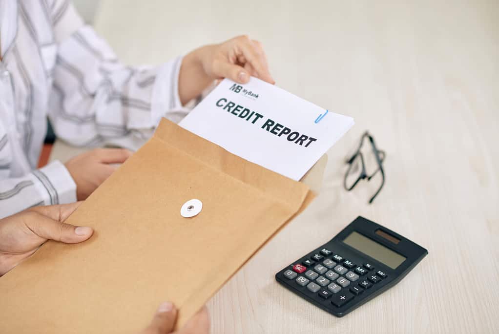 Collections agency worker showing papers of credit report sitting at table
