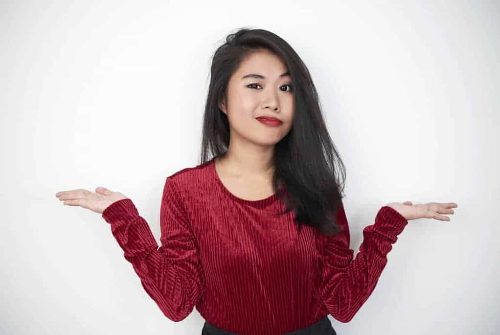 Portrait of frustrated young girl shrugging and asking something isolated on white background